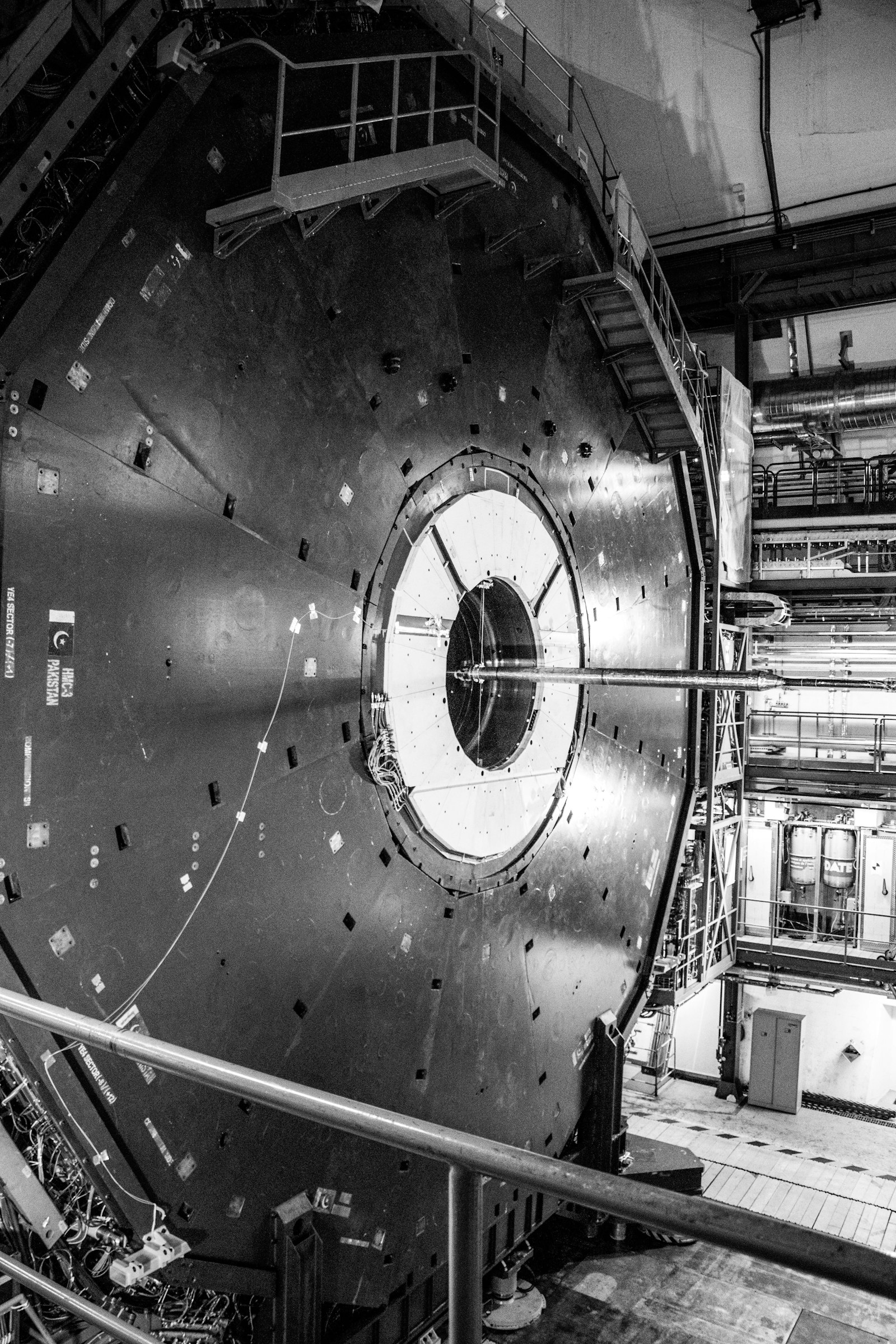 A large circular particle-physics detector seen from a gantry inside an experimental hall