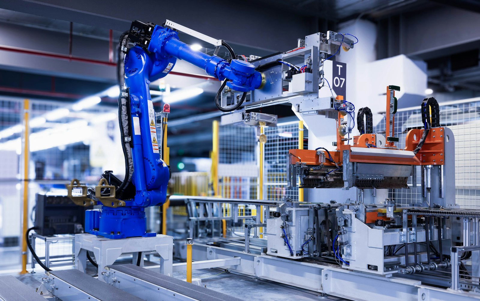 A blue industrial robot arm on an automated factory line