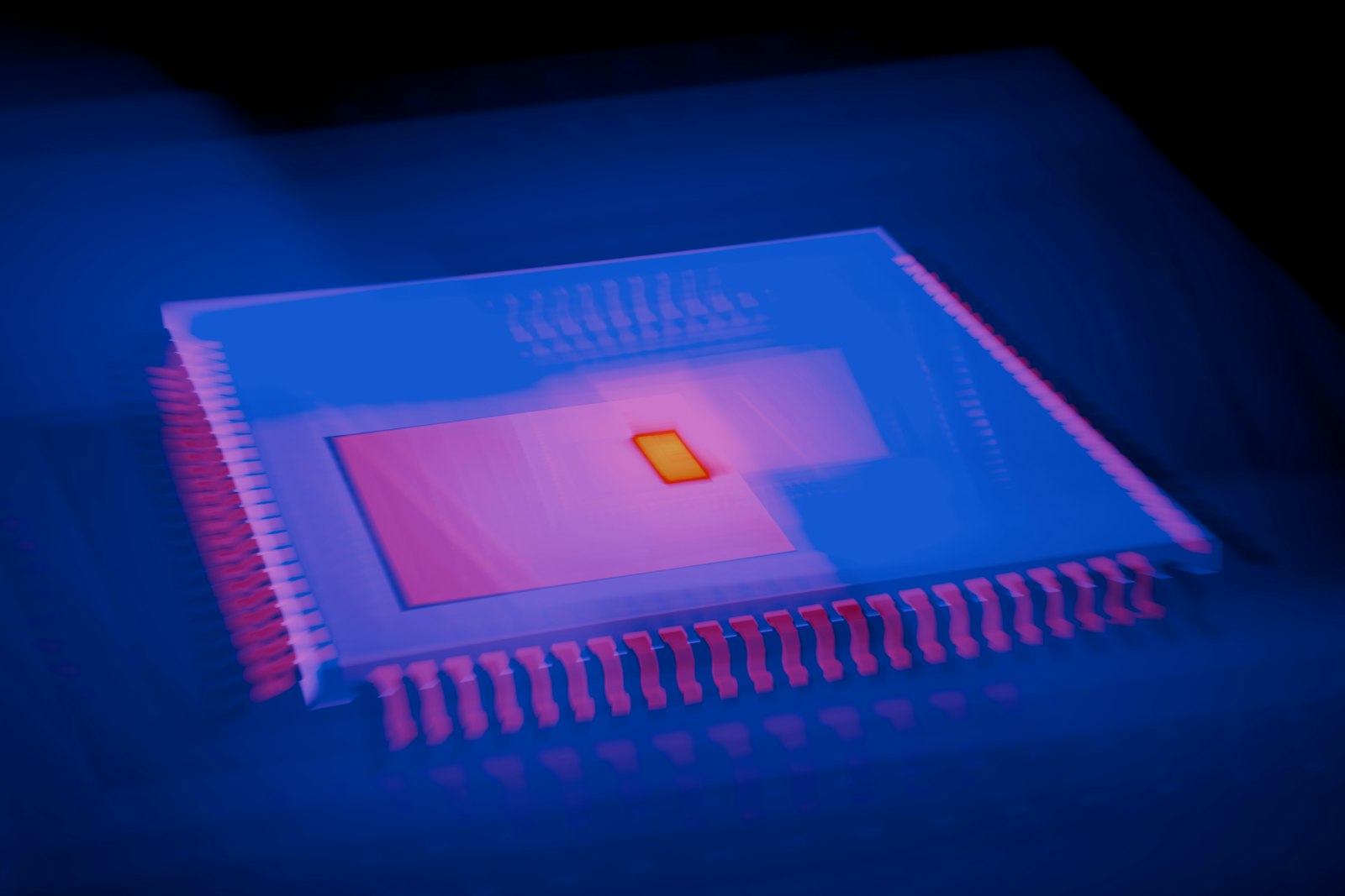 A processor chip lit in blue and pink in a dark lab